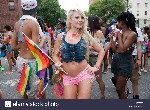 a beautiful blond woman carries a rainbow flag at the gay pride parade C5GYR5